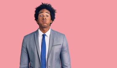 Afro saçlı, iş ceketi giyen, komik yüzlü, yanakları şişen yakışıklı Afro-Amerikan bir adam. Havayla şişmiş ağız, çılgın bir ifade.. 
