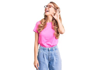 Sarışın, güzel, beyaz bir kadın. Günlük kıyafetler ve gözlük takıyor. Kulaktan kulağa gülümsüyor. Sağırlık kavramı. 