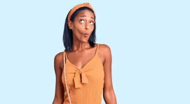 Genç Afro-Amerikan kadın yaz kıyafeti giyip dudaklarıyla balık suratı yapıyor, çılgınca ve komik bir jest. Komik ifade. 