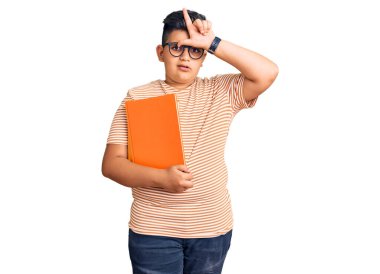 Küçük çocuk kitap tutuyor gözlük takıyor. Alnında parmakları olan insanlarla dalga geçiyor. Ezik jestler yapıyor.. 