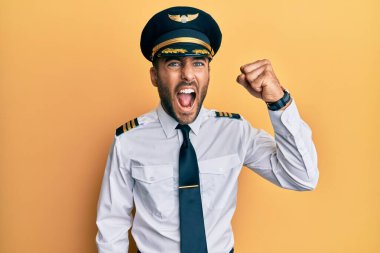 Yakışıklı, İspanyol pilot üniforması giyen kızgın ve kızgın yumruk kaldıran öfkeli ve öfkeyle bağıran bir adam. öfke ve agresif konsept. 