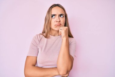 Genç, güzel, sarışın, gündelik kıyafetler giyen, ciddi yüzlü, eli çenesinde sorular soran, kafa karıştırıcı fikirleri düşünceli bir kadın. 