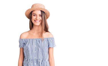 Şapka ve tişört giyen, yüzünde mutlu ve havalı bir gülümseme olan genç ve güzel bir kız. şanslı kişi. 