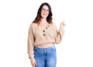 Güzel, genç, esmer bir kadın. Günlük kıyafetler ve gözlük takıyor. Yüzünde kocaman bir gülümseme var.. 