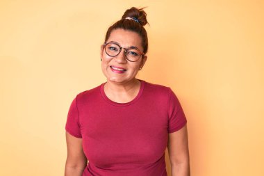Orta yaşlı esmer, sıradan kıyafetler giyen, mutlu ve havalı bir gülümsemesi olan İspanyol bir kadın. şanslı kişi. 