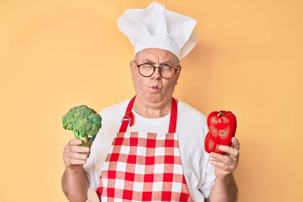 Ανώτερος Γκριζομάλλης Άντρας Που Φοράει Επαγγελματική Ποδιά Μάγειρας Κρατώντας Μπρόκολο — Φωτογραφία Αρχείου