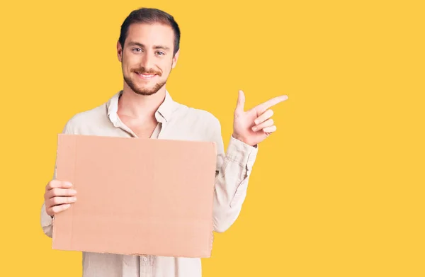 Young Handsome Caucasian Man Holding Empty Cardboard Banner Smiling Happy — Stock Photo, Image