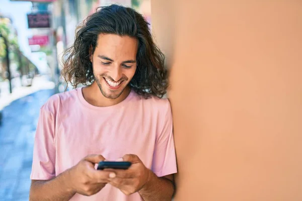 Jonge Spaanse Man Glimlachen Blij Met Behulp Van Smartphone Leunend — Stockfoto