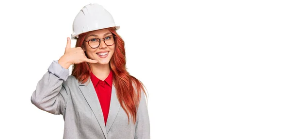 Young Redhead Woman Wearing Architect Hardhat Smiling Doing Phone Gesture — Stock Photo, Image