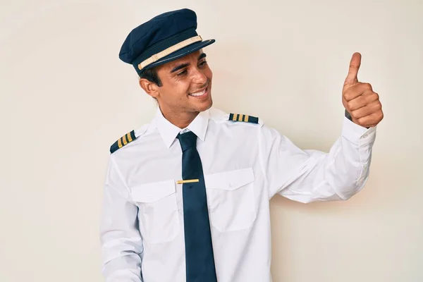 Junger Hispanischer Mann Flugzeugpilotenuniform Sieht Stolz Aus Lächelt Und Hebt — Stockfoto