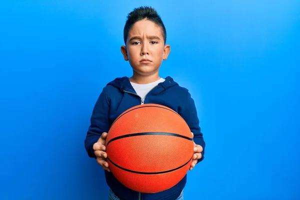 Malý Chlapec Hispánský Kluk Drží Basketbal Skeptický Nervózní Mračí Kvůli — Stock fotografie
