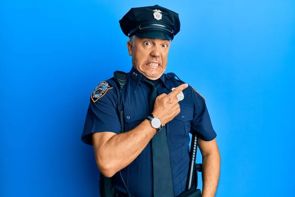 Handsome middle age mature man wearing police uniform pointing aside worried and nervous with forefinger, concerned and surprised expression
