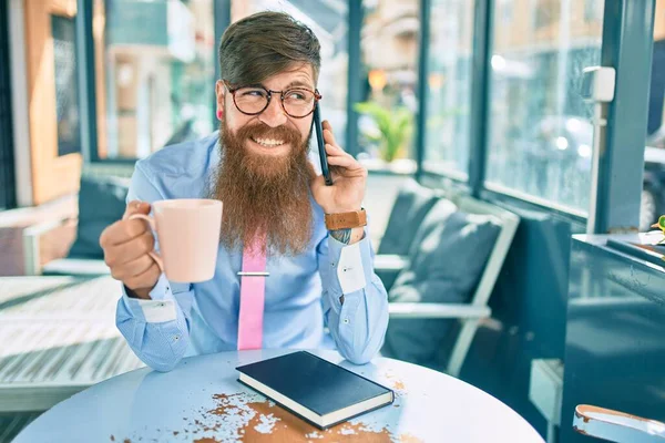 Młody Rudy Biznesmen Rozmawia Przez Smartfona Pije Kawę Tarasie Kawiarni — Zdjęcie stockowe