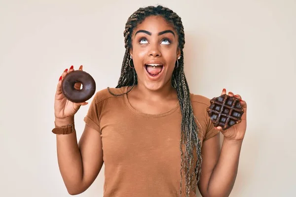 Joven Mujer Afroamericana Con Trenzas Sosteniendo Rosquilla Chocolate Gofre Enojado —  Fotos de Stock