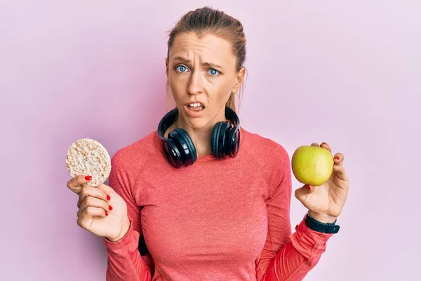 Hermosa Mujer Deportiva Caucásica Sosteniendo Manzana Verde Galletas Arroz Cara —  Fotos de Stock