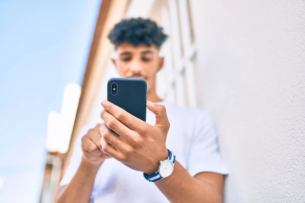 Hombre Árabe Joven Sonriendo Feliz Usando Teléfono Inteligente Apoyado Pared —  Fotos de Stock