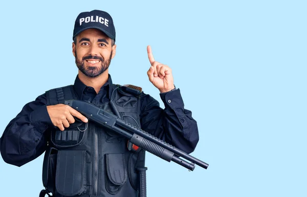 Jovem Hispânico Vestindo Uniforme Policial Segurando Espingarda Surpreso Com Uma — Fotografia de Stock