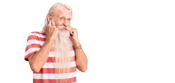 年长的男人 头发灰白 胡须很长 穿着条纹T恤 用手指捂住耳朵 对嘈杂的音乐感到恼怒 聋人概念 — 图库照片