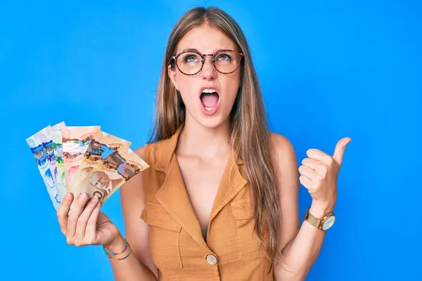 Young Blonde Girl Holding Canadian Dollars Angry Mad Screaming Frustrated — Stock Photo, Image