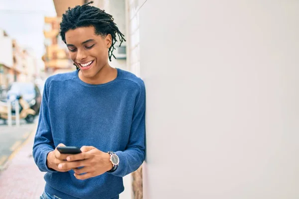 Νεαρός Αφροαμερικάνος Χαμογελώντας Χαρούμενος Χρησιμοποιώντας Smartphone Ακουμπώντας Στον Τοίχο — Φωτογραφία Αρχείου
