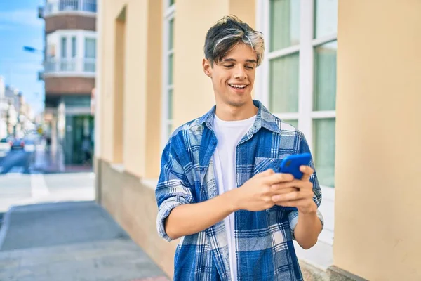 Joven Hombre Hispano Sonriendo Feliz Usando Smartphone Ciudad —  Fotos de Stock