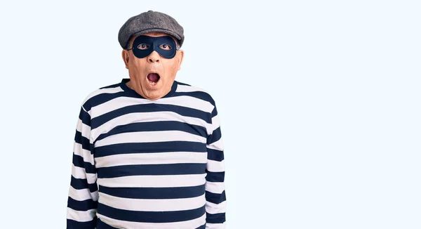 Älterer Gutaussehender Mann Mit Einbrechermaske Und Shirt Verängstigt Und Schockiert — Stockfoto