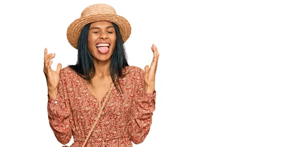 夏の帽子をかぶっている若いアフリカ系アメリカ人女性は 腕を上げて興奮して叫んで目を閉じて成功のために狂気と狂気を祝います 勝者のコンセプト — ストック写真