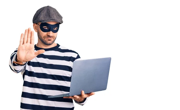 Jonge Knappe Man Draagt Inbraak Masker Met Behulp Van Laptop — Stockfoto