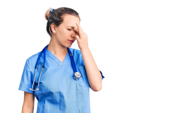 Jovem Mulher Loira Bonita Vestindo Uniforme Médico Estetoscópio Cansado Esfregando — Fotografia de Stock