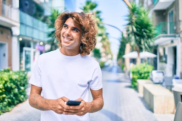 Ung Latinamerikansk Man Ler Glad Med Smartphone Gatan Staden — Stockfoto