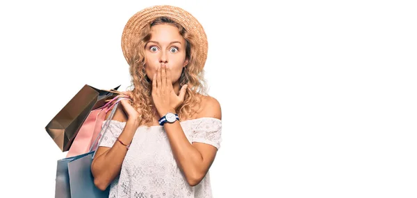 Beautiful Caucasian Woman Holding Shopping Bags Covering Mouth Hand Shocked — Stock Photo, Image