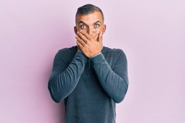 Sıradan kıyafetler giyen orta yaşlı yakışıklı bir adam yanlışlıkla elleriyle ağzını kapatırken şok oldu. gizli kavram. 