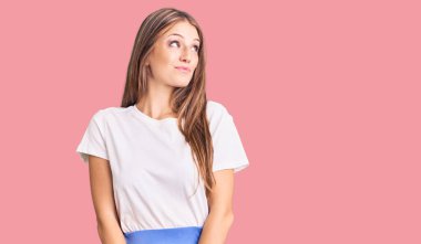 Genç, güzel, sarışın, yaz tarzı giyinen, gülümseyen, yan bakan ve düşünen bir kadın.. 