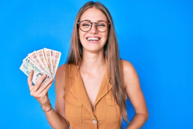 Genç sarışın kız, Birleşik Krallık 'ı elinde tutuyor. Gülmekten kırılıyor ve kahkahalar atıyor.. 