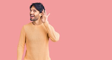 Yakışıklı, sıradan süveter giyen, ağzı kulaklarında gülümseyen dedikoduları ve dedikoduları dinleyen bir İspanyol. Sağırlık kavramı. 