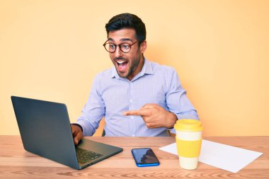 Ofiste çalışan genç İspanyol bir adam bir fincan kahve içip gülümsüyor. 