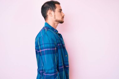 Sıradan kıyafetler giyen, rahat bir görünüm takınan, doğal yüzlü ve kendine güvenen genç yakışıklı bir adam.. 