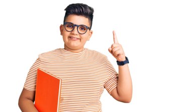 Gözlüklü küçük çocuk kitabı tutup başarılı bir fikirle işaret etti. Heyecanlı ve mutlu. Bir numara.. 
