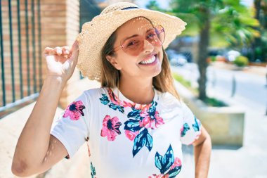 Şehirde kalp gözlüğü takan, gülümseyen orta yaşlı İspanyol kadın.