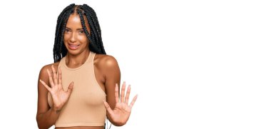 Güzel İspanyol kadın gündelik giysiler giyiyor, tiksindirici bir ifade takınıyor, tiksindirici bir yüz ifadesi takınıyor ve tiksindirici bir ifade takınıyor. Eller havada. 