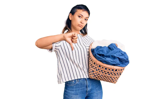 Ung Kvinna Håller Tvättkorg Med Argt Ansikte Negativa Tecken Visar — Stockfoto