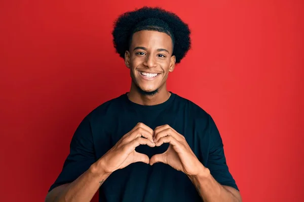 黑头发的非裔美国人穿着休闲装 带着爱心微笑 手握心形符号 浪漫的概念 — 图库照片