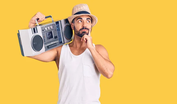 Young Hispanic Man Holding Boombox Listening Music Serious Face Thinking — Stock Photo, Image