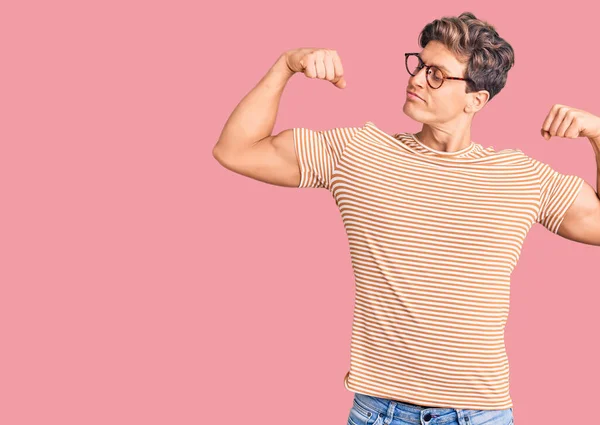 Homem Bonito Jovem Vestindo Roupas Casuais Óculos Mostrando Músculos Braços — Fotografia de Stock