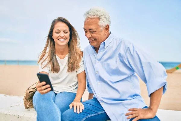 Casal Hispânico Meia Idade Usando Smartphone Sentado Banco Praia — Fotografia de Stock