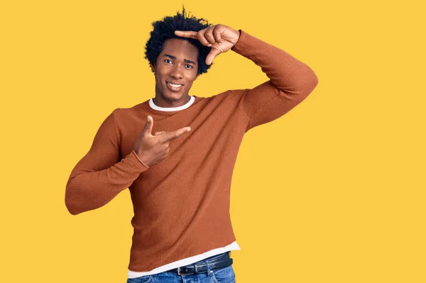 アフロの髪をしたハンサムなアフリカ系アメリカ人の男性は 幸せな顔で手や指でフレームを作る笑顔カジュアルな服を着ています 創造性と写真の概念 — ストック写真