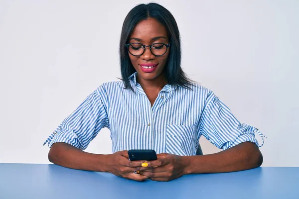 Νεαρή Αφροαμερικανή Γυναίκα Που Χρησιμοποιεί Smartphone Κάθεται Στο Τραπέζι Και — Φωτογραφία Αρχείου