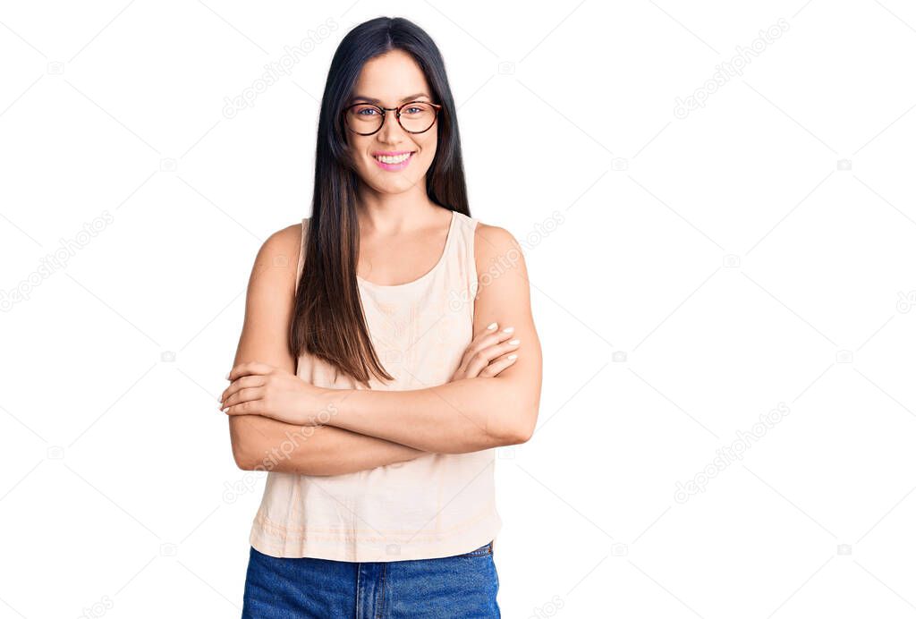 Young beautiful caucasian woman wearing casual clothes and glasses happy face smiling with crossed arms looking at the camera. positive person. 