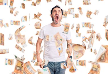 Orta yaşlı yakışıklı bir adam günlük tişört giyiyor kızgın ve kızgın bağırıyor sinirli ve öfkeli, öfkeyle bağırıyor. öfke ve agresif konsept.