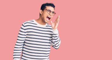 Sıradan kıyafetler ve gözlük takmış İspanyol yakışıklı genç adam el ele tutuşarak bağırıyor ve bağırıyordu. iletişim konsepti. 